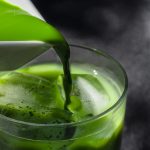 a pitcher pouring green liquid into a glass