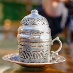 a silver teapot sitting on top of a wooden table